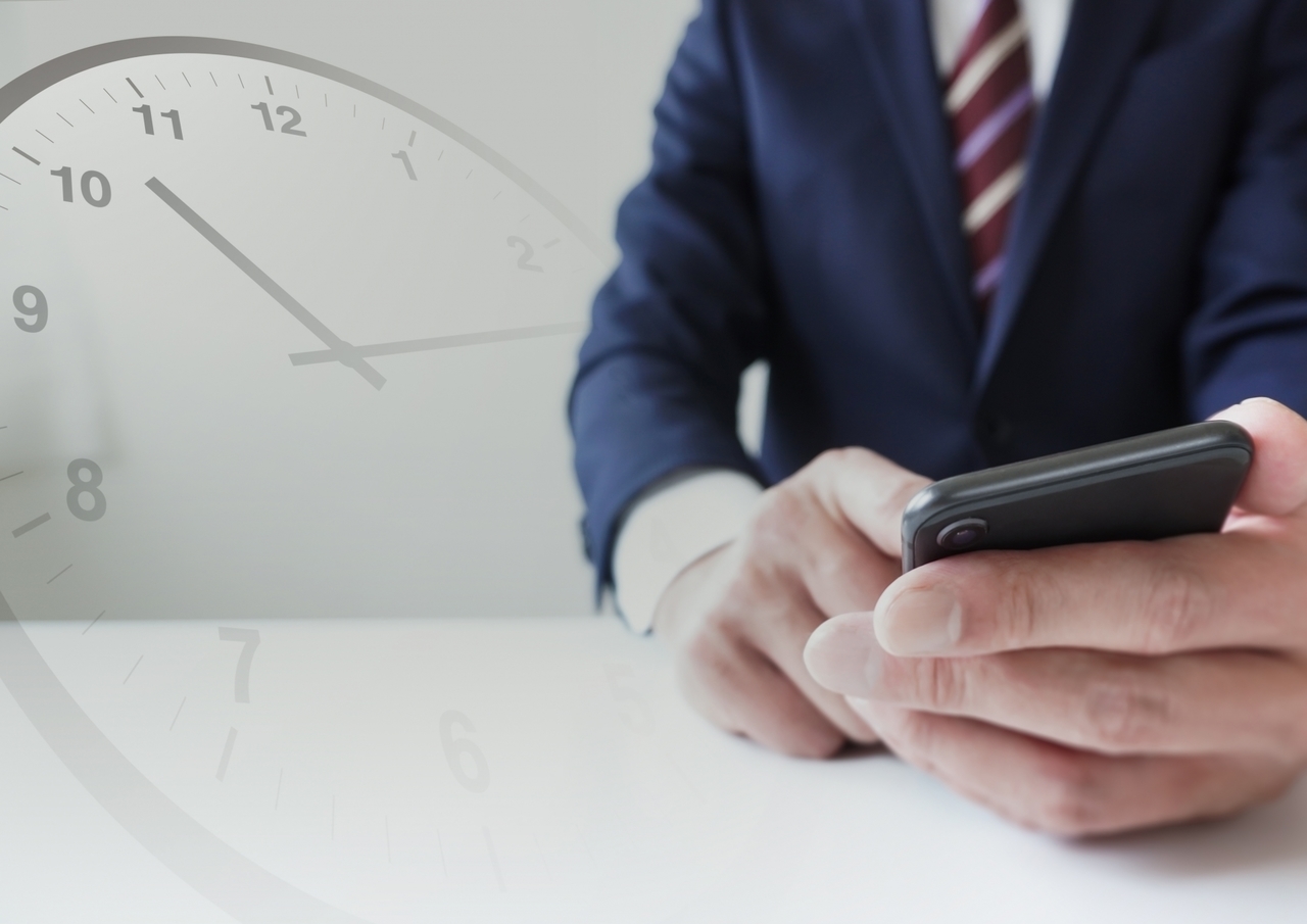 ビジネスマンのスマホと時計のイメージ